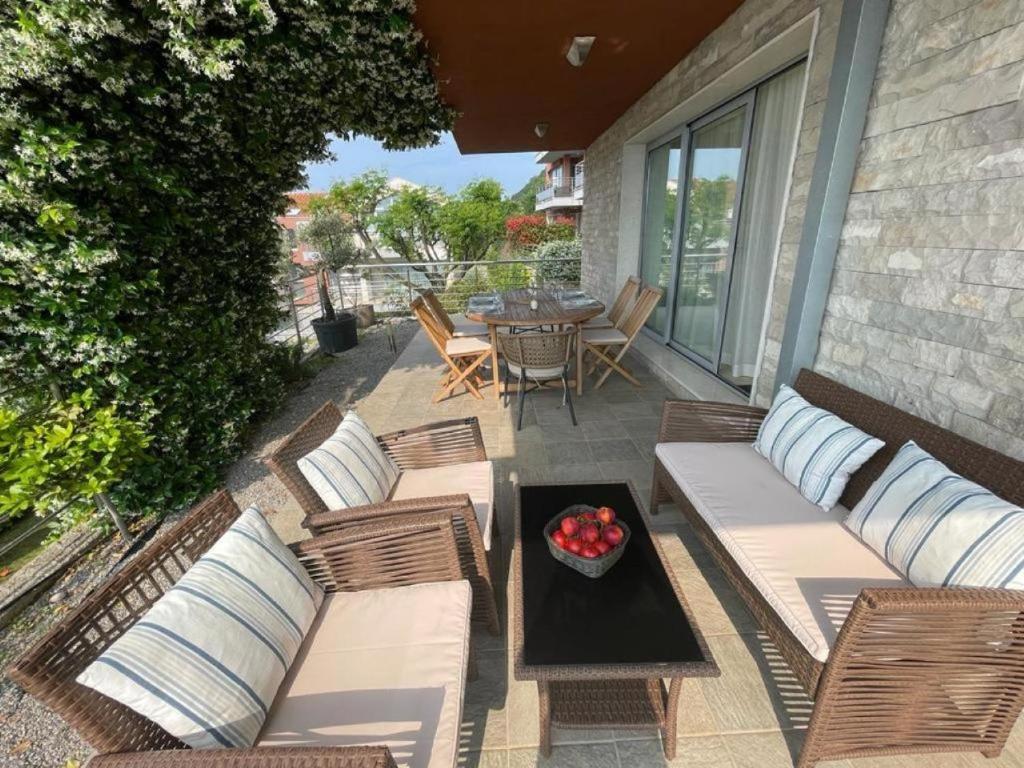 patio z krzesłami i stołem z misą owoców w obiekcie Acacia Hill Apartment C01 w mieście Ðenovići