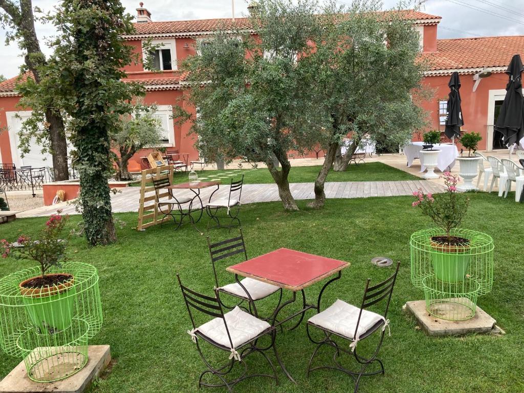 uma mesa e cadeiras num quintal com árvores em Domaine Sainte Baume em Saint-Maximin-la-Sainte-Baume