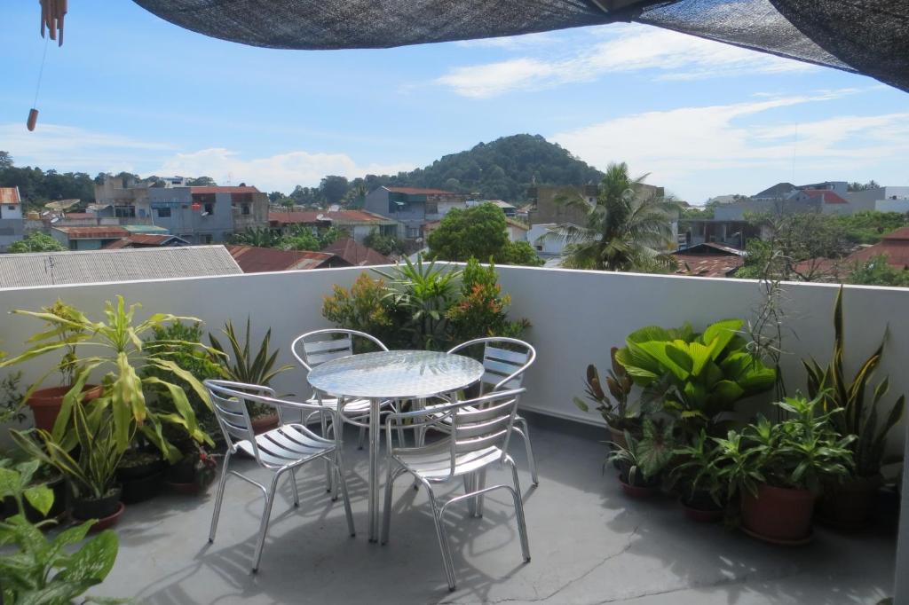 einen Tisch und Stühle auf einem Balkon mit Pflanzen in der Unterkunft Nola's Homestay in Kampungdurian
