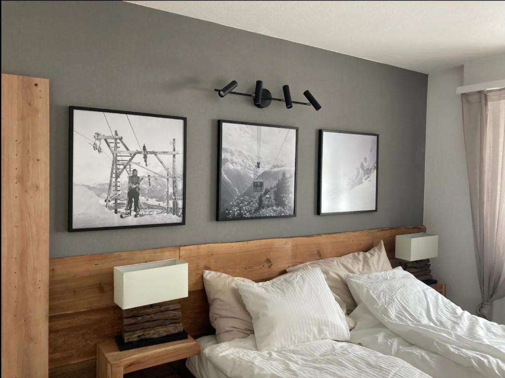 - une chambre dotée d'un lit avec 4 photos sur le mur dans l'établissement Best views and location in Leukerbad!, à Loèche-les-Bains