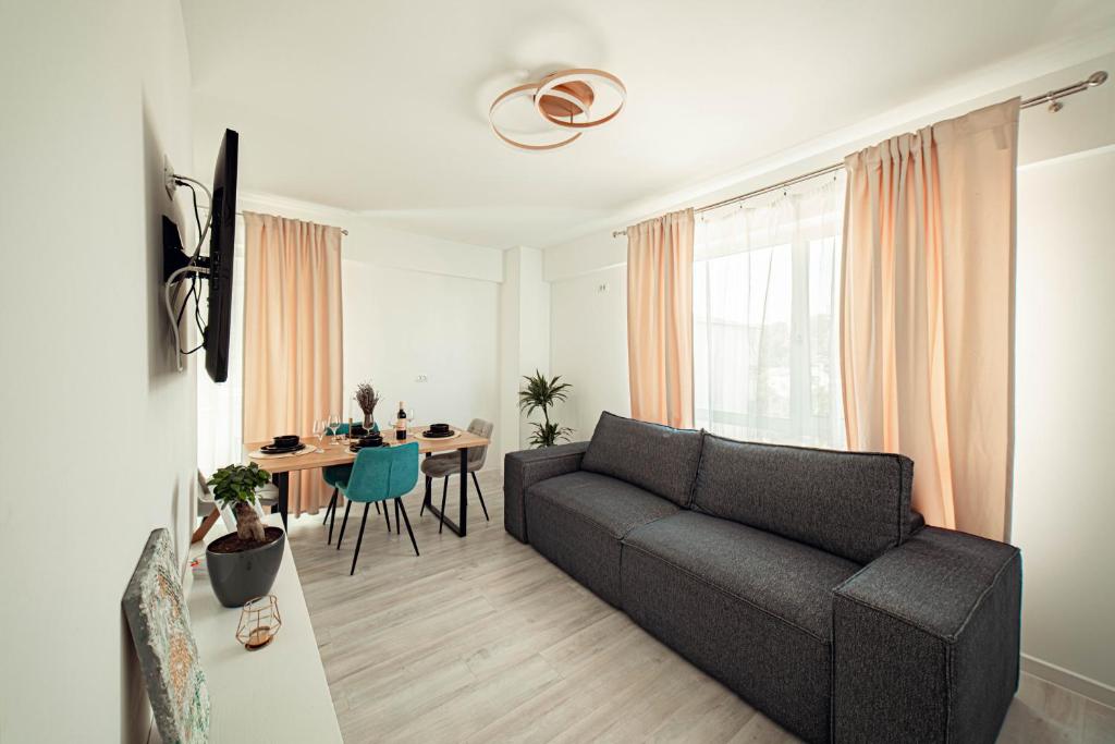 uma sala de estar com um sofá e uma mesa em Bright and Cozy Studios and Flats - Palas Mall em Iaşi