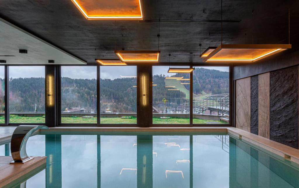 a swimming pool in a building with a large window at Didukh Eco Hotel&Spa in Bukovel