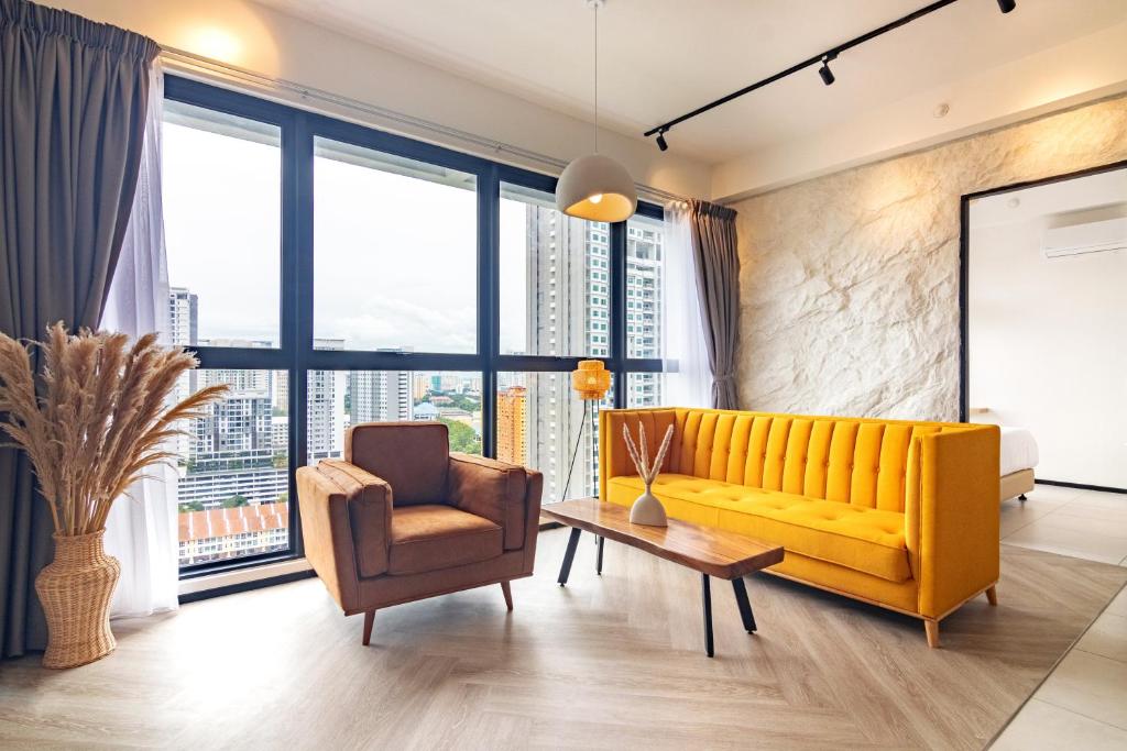 uma sala de estar com um sofá amarelo e uma cadeira em Urban Suites, Autograph Collection by Stellar ALV em Jelutong