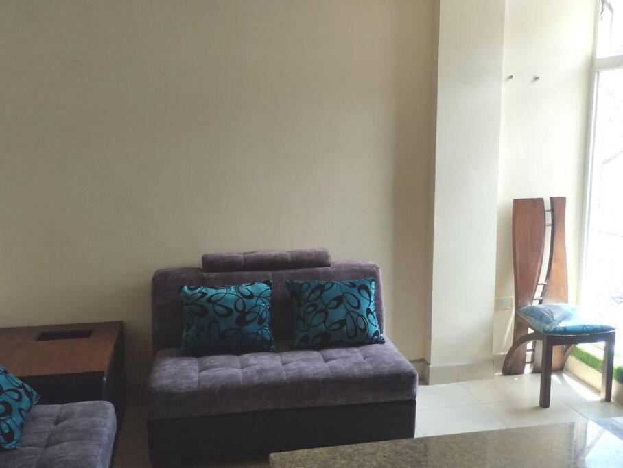 sala de estar con sofá y silla en departamento individual equipado, en Ibarra