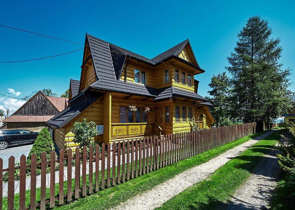 une maison en bois avec une clôture devant elle dans l'établissement Dom Rodzinny, à Ząb
