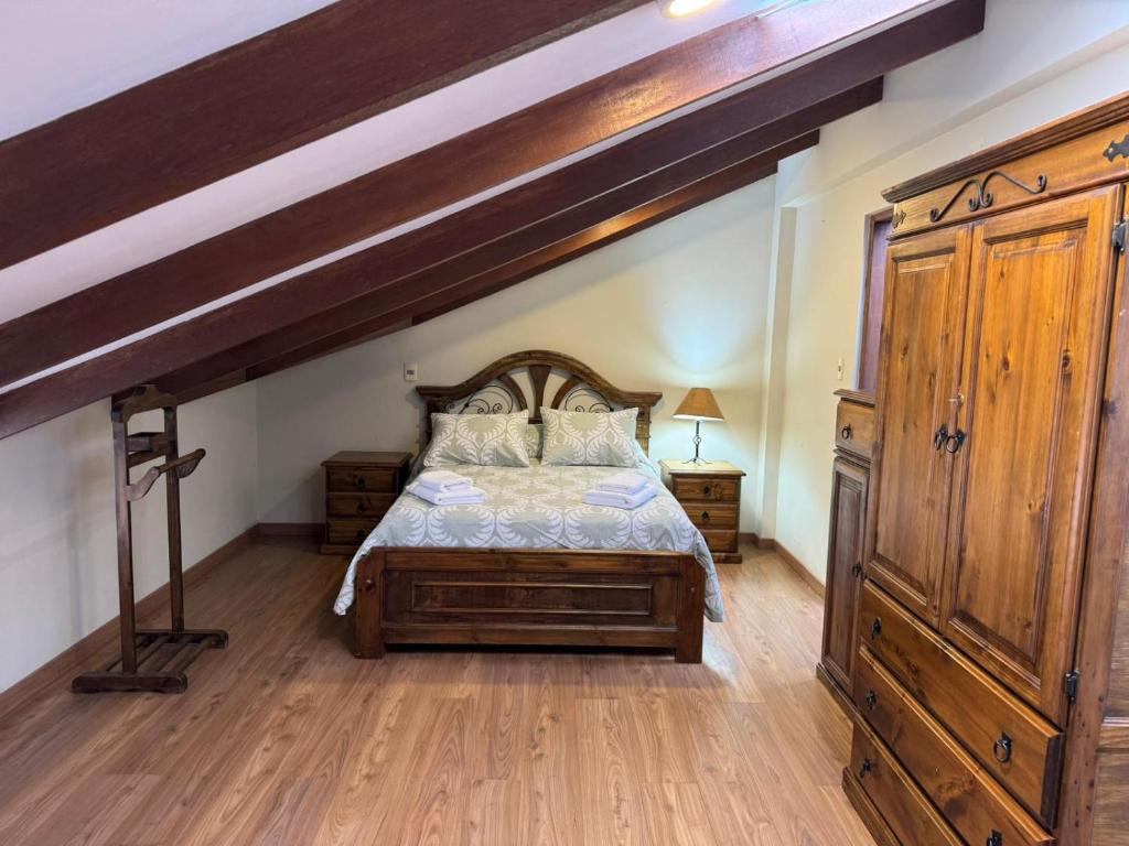 een slaapkamer met een groot bed en een houten kast bij Abis Terraza in Sucre