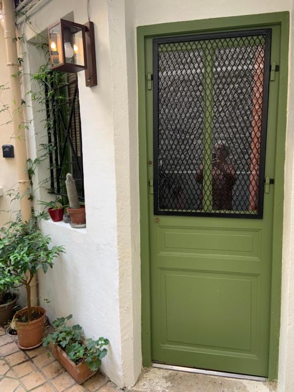 une porte verte sur une maison avec des plantes en pot dans l&#39;établissement Maison Boinod, à Paris