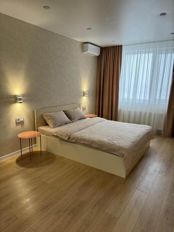 ヴィーンヌィツャにあるЛюкс Апартаменты Cream Pearl на подольеのベッドルーム(大型ベッド1台、窓付)