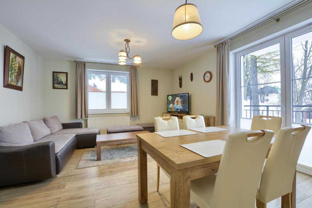 ein Wohnzimmer mit einem Tisch und einem Sofa in der Unterkunft Apartament u Jacentego in Szklarska Poręba