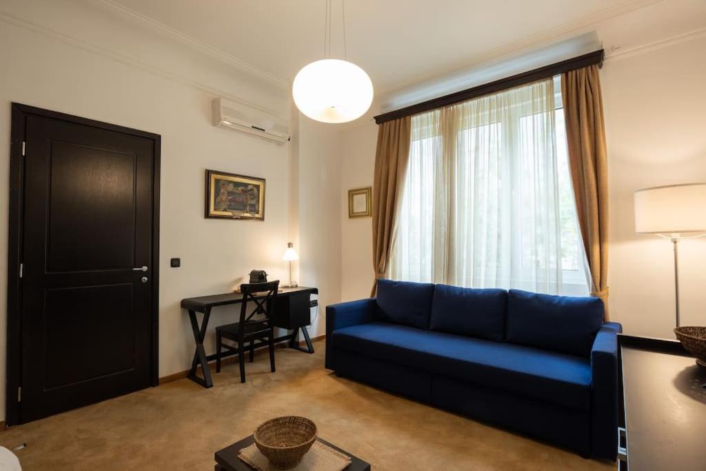 een woonkamer met een blauwe bank en een tafel bij Belgrade Center Apartment Lux V in Belgrado
