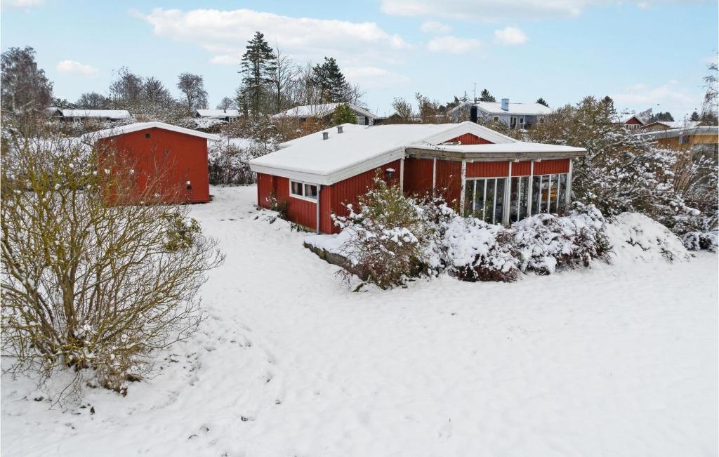 una casa è coperta di neve in un cortile di 3 Bedroom Nice Home In Bog By a Bogø By