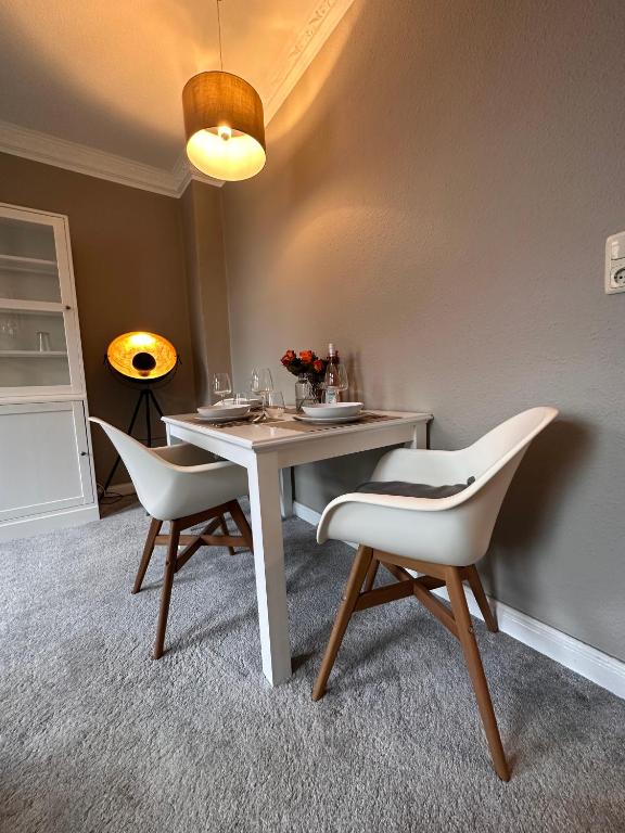 - une salle à manger avec une table et deux chaises dans l'établissement Moderner Altbaucharme in zentraler Lage, à Kiel