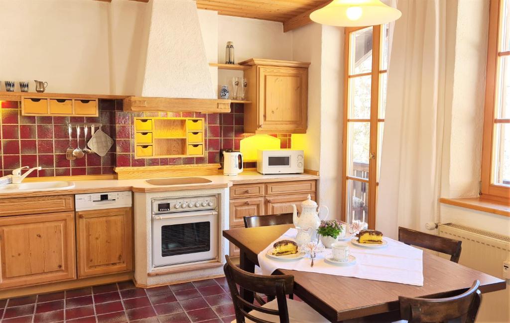 een keuken met een houten tafel en een eetkamer bij Ferienwohnung im Gästehaus Sieger-Brandner in Ramsau