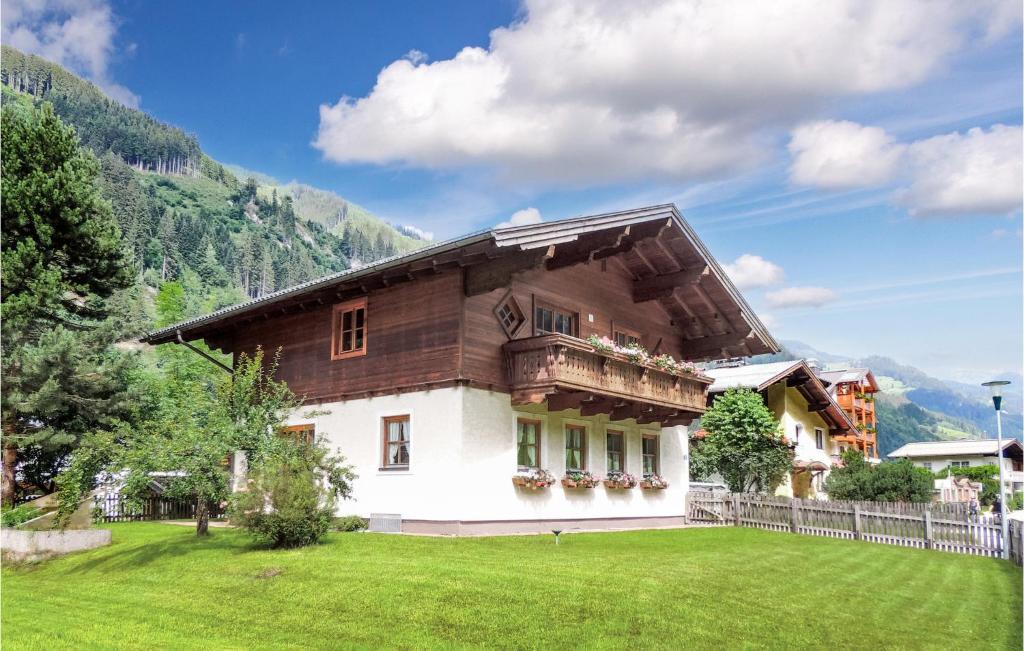 a house with a balcony on a green lawn at Große Ferienwohnung Grossarl in Grossarl