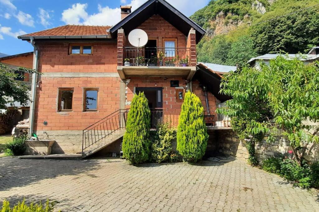 una casa in mattoni con balcone su un vialetto di mattoni di Vejtse House 