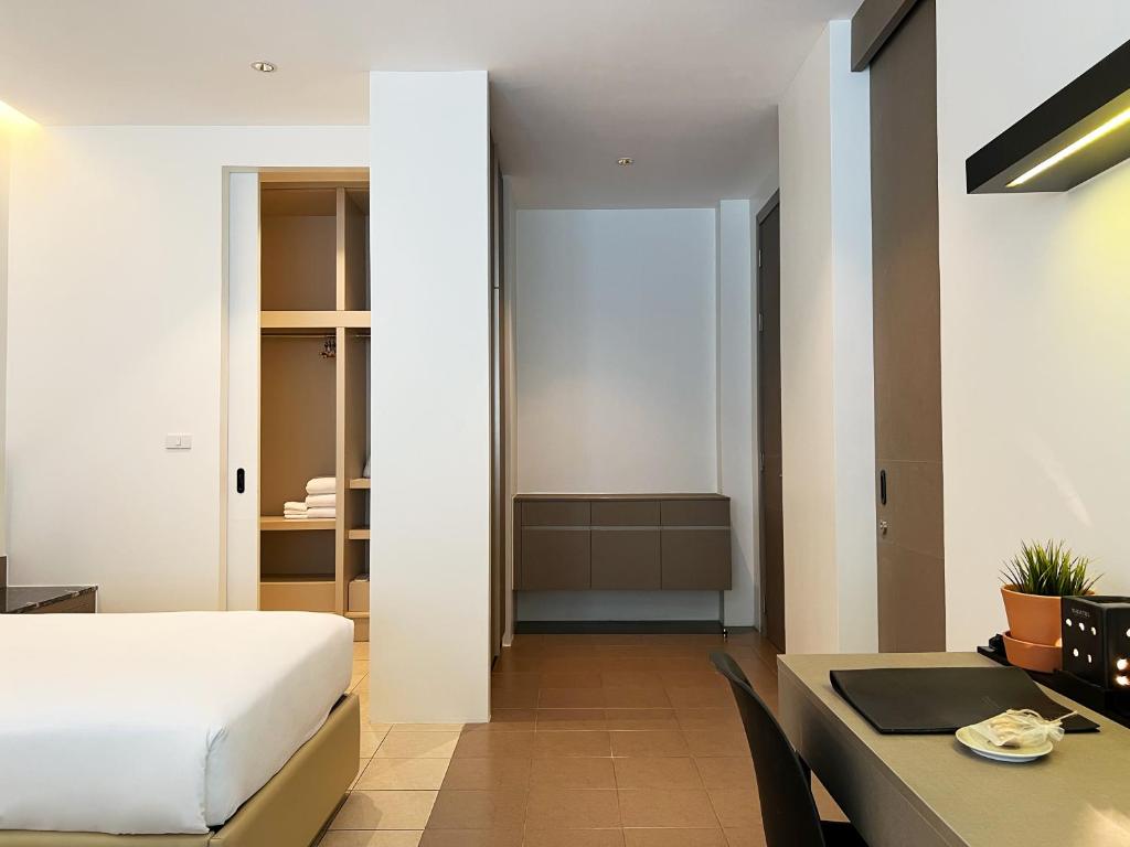 The entry-side view shows an open wardrobe, drawers and the room’s compact desk.