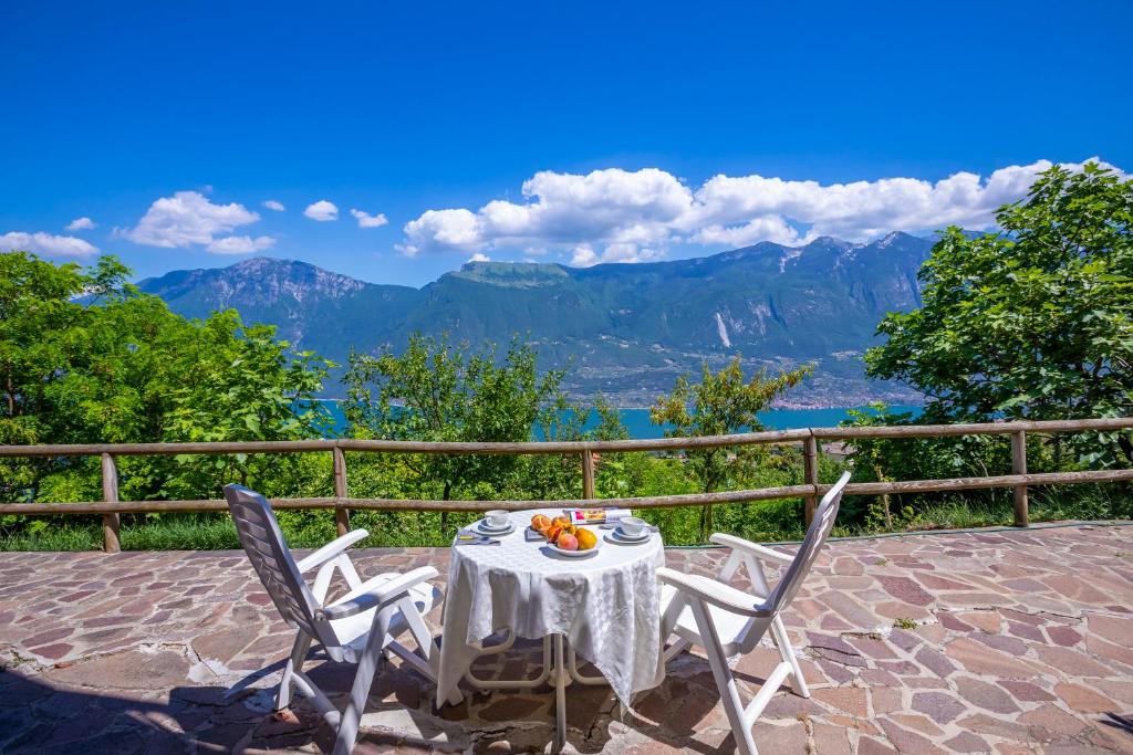 a table and chairs with a view of the mountains at Appartamenti Secrel in Tremosine Sul Garda