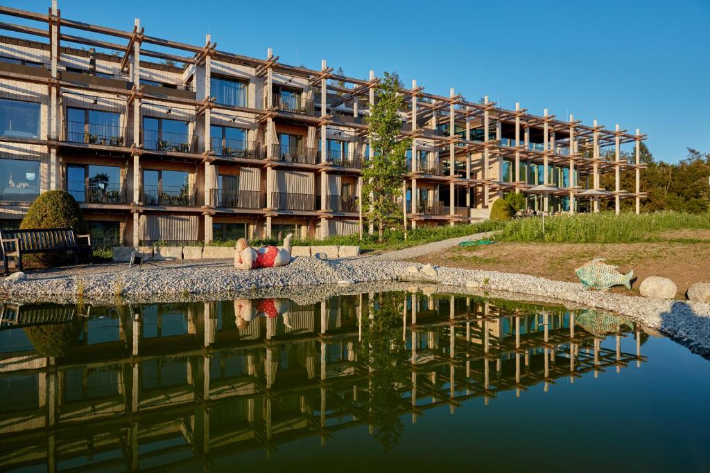 a building with a reflection in a body of water at Hotel BERGEBLICK in Bad Tölz