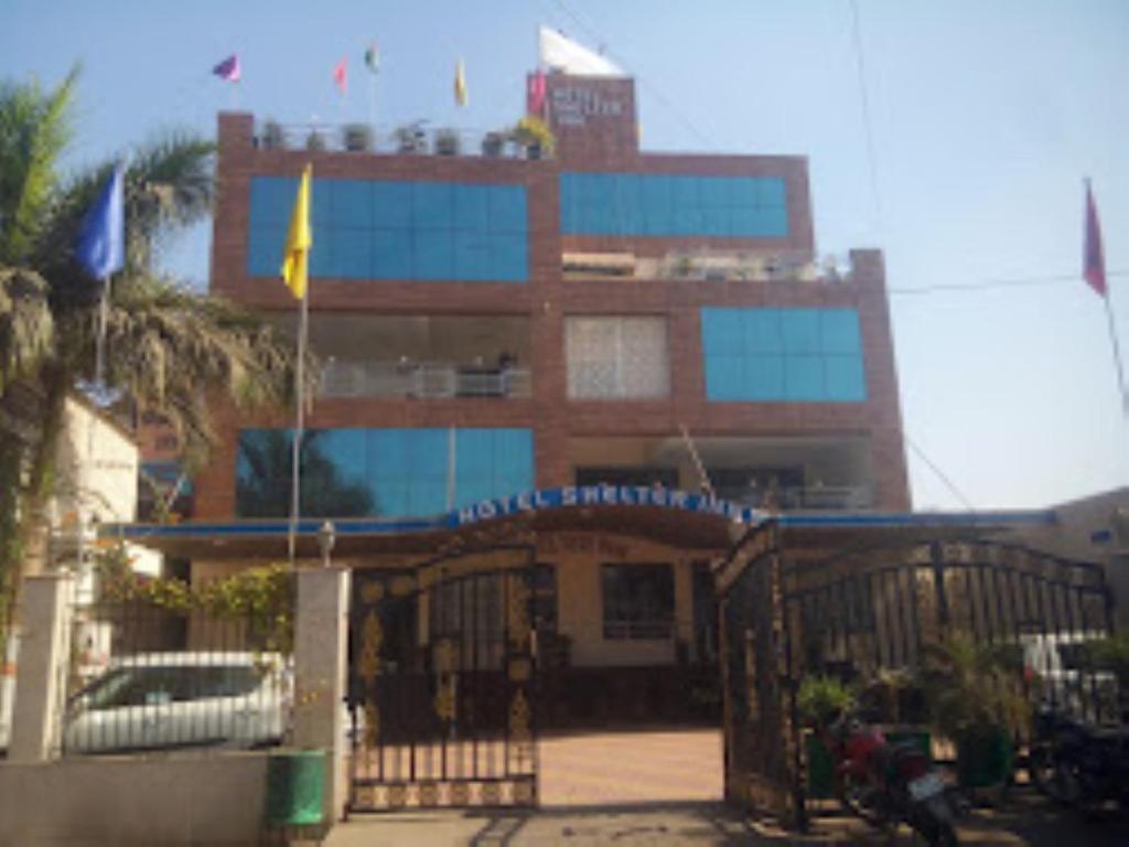 a large building with flags in front of it at Hotel Shelter Inn,Chhatarpur in Chhatarpur