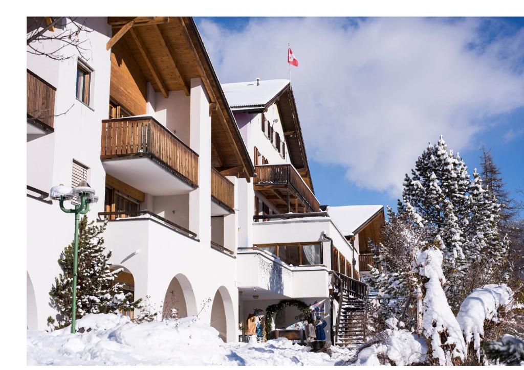 ein Gebäude im Schnee mit einer Fahne darauf in der Unterkunft Aparthotel Muchetta in Davos