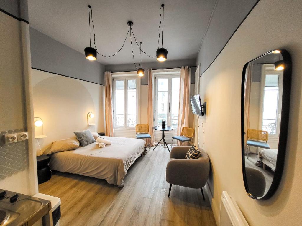 a small bedroom with a bed and a mirror at Suite Oxymore in Lyon