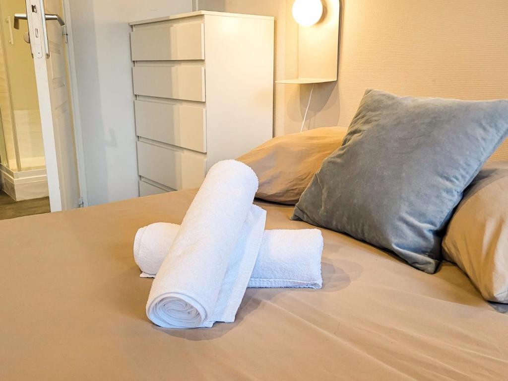 two rolls of towels sitting on top of a bed at Suite Oxymore in Lyon