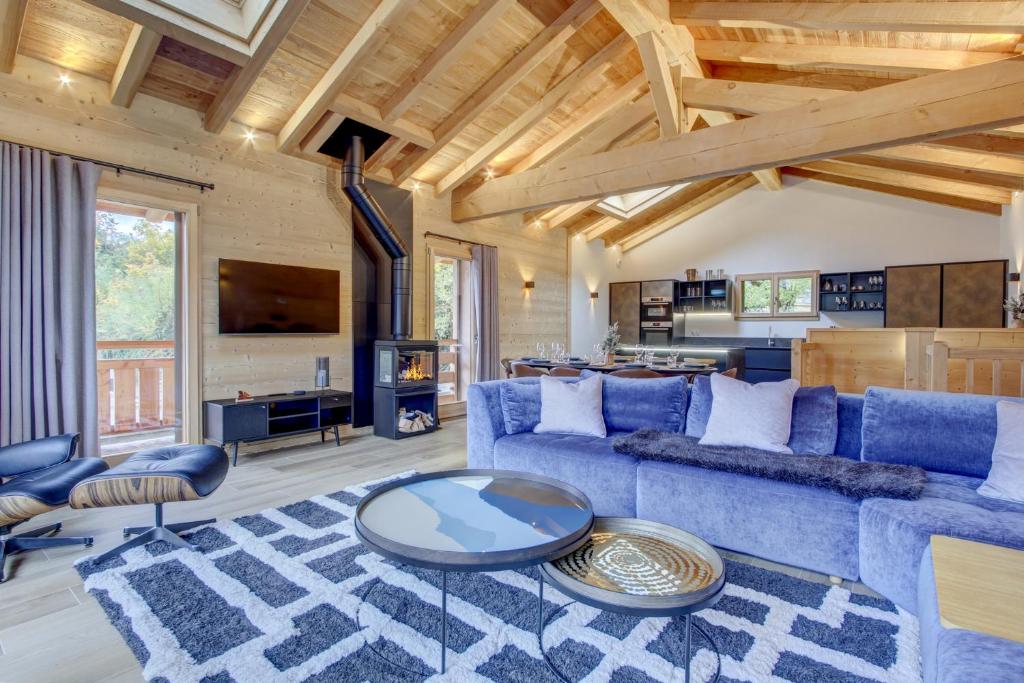 a living room with a blue couch and a table at Chalet Tilly in Morzine