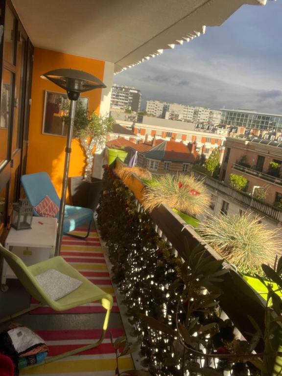a balcony with plants and a view of a city at A L'OMBRE DE LA TOUR EIFFEL AU BORD DE LA SEINE in Paris