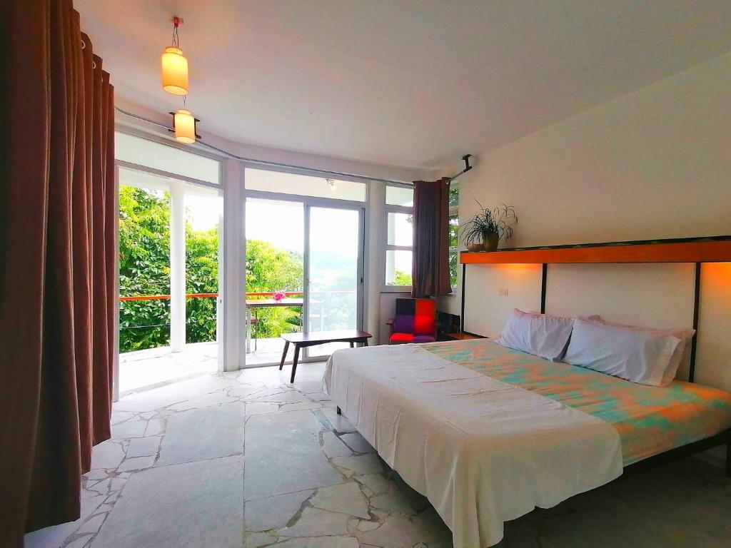 a bedroom with a large bed and a large window at Lonos Circle Ocean View Room in Romblon