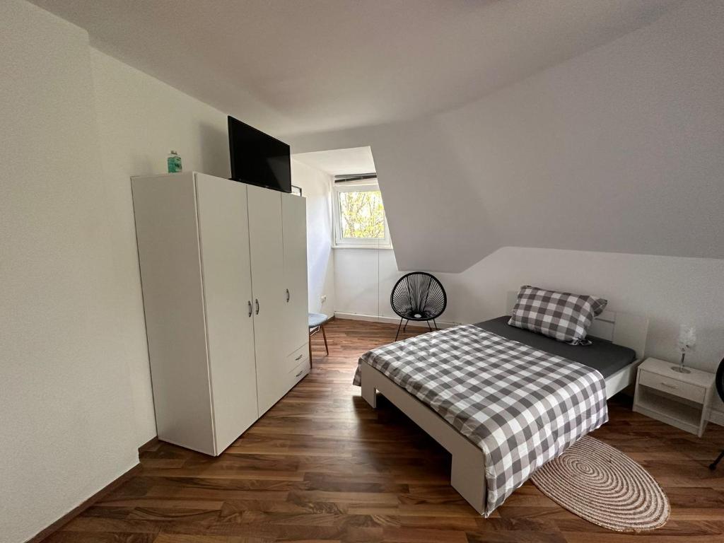 sypialnia z łóżkiem i białą szafką w obiekcie Schönes Zimmer im Zentrum - 2 w mieście Paderborn
