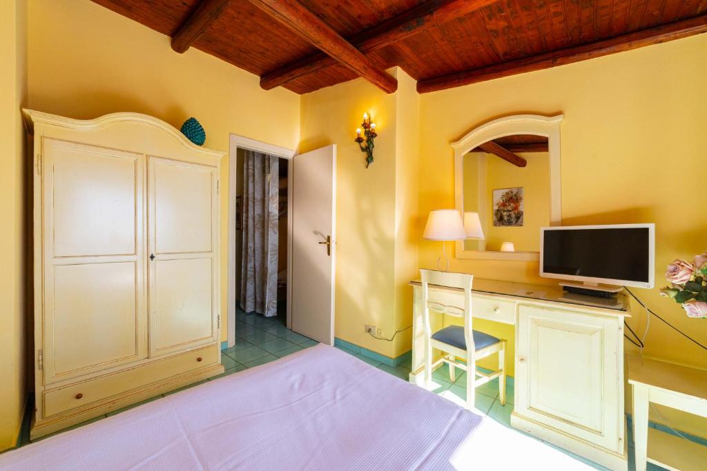 a room with a desk with a tv on it at Mendolia Beach Hotel in Taormina