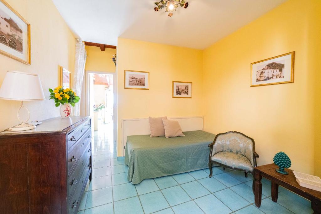 a bedroom with a bed and a desk and a chair at Mendolia Beach Hotel in Taormina