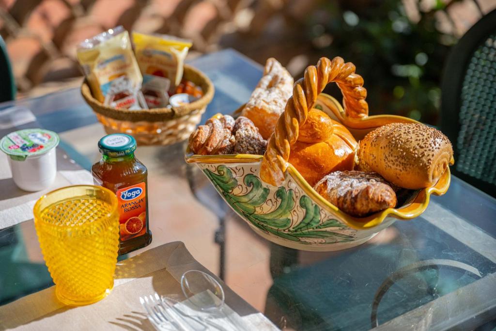 a table with a bowl of food and a basket of bread at Mendolia Beach Hotel in Taormina