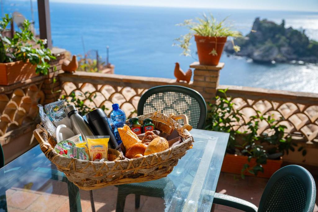 a basket of food on a table with a view of the ocean at Mendolia Beach Hotel in Taormina