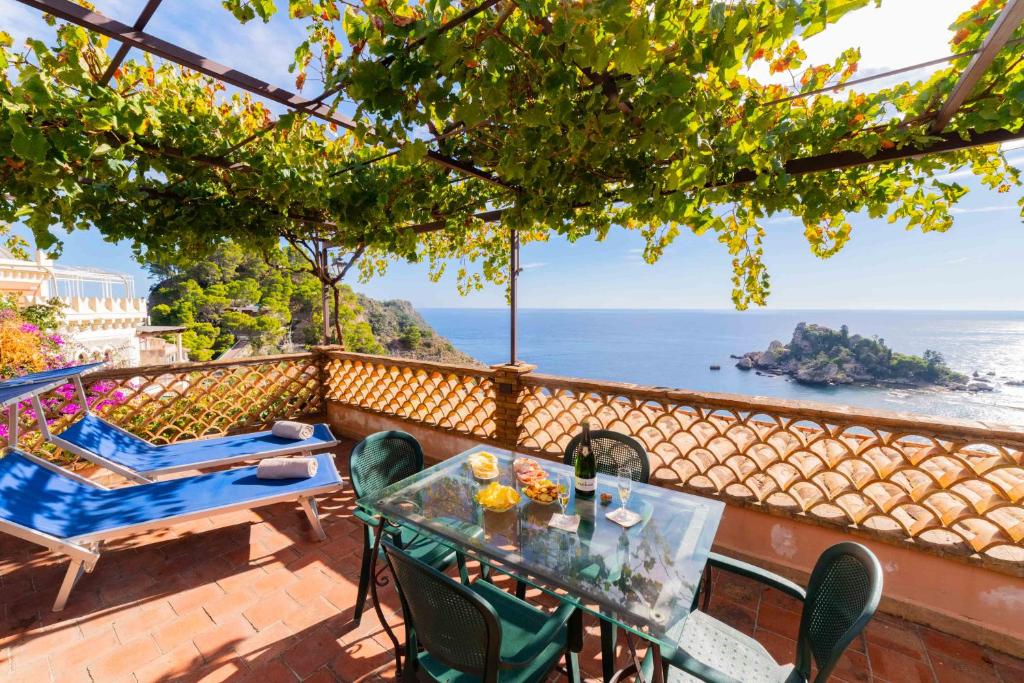 a table and chairs on a balcony with a view of the ocean at Mendolia Beach Hotel in Taormina