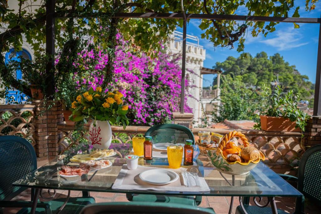 a table with food and drinks on a patio at Mendolia Beach Hotel in Taormina