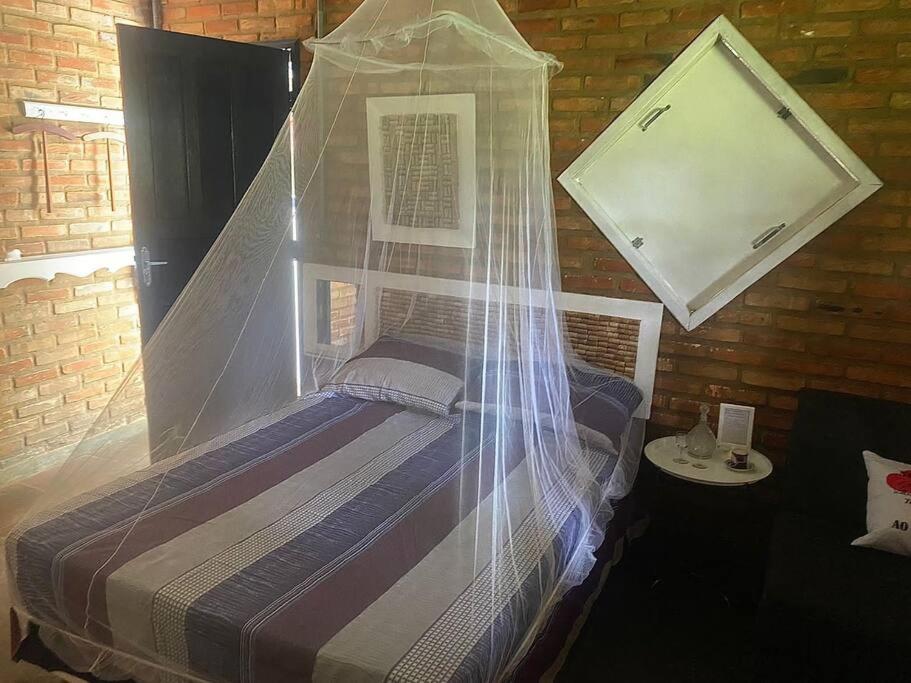 1 cama con dosel de plástico en una habitación en Refugio do Amor en São João del Rei