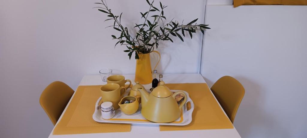 a table with a yellow tea set and a vase at Athenian Asty Guesthouse in Athens