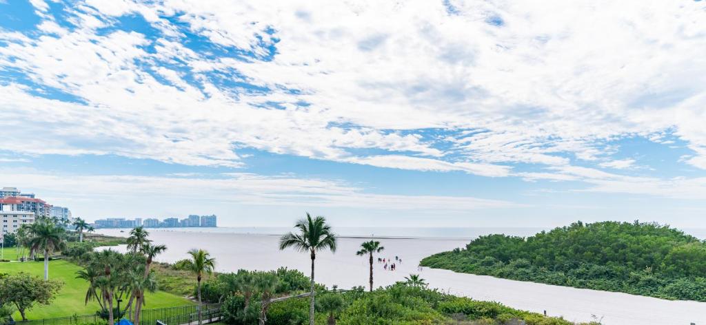a view of a body of water with palm trees at Updated 2 Bed Condo Offering Long Beach Views From Balcony in Marco Island