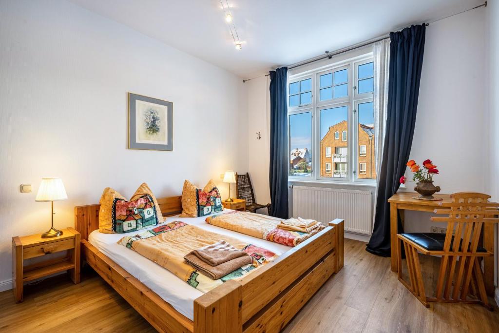 a bedroom with a bed and a large window at Haus Übersee Wohnung Timbuktu in Travemünde