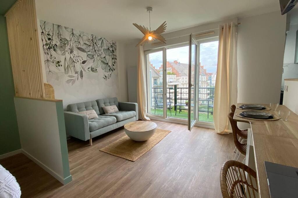 ein Wohnzimmer mit einem Sofa und einem Tisch in der Unterkunft Appart Hôtel Lison - rénové 2023 Vieux Lille in Lille