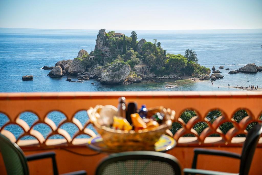 a basket of food on a table in front of the ocean at Mendolia Beach Hotel in Taormina