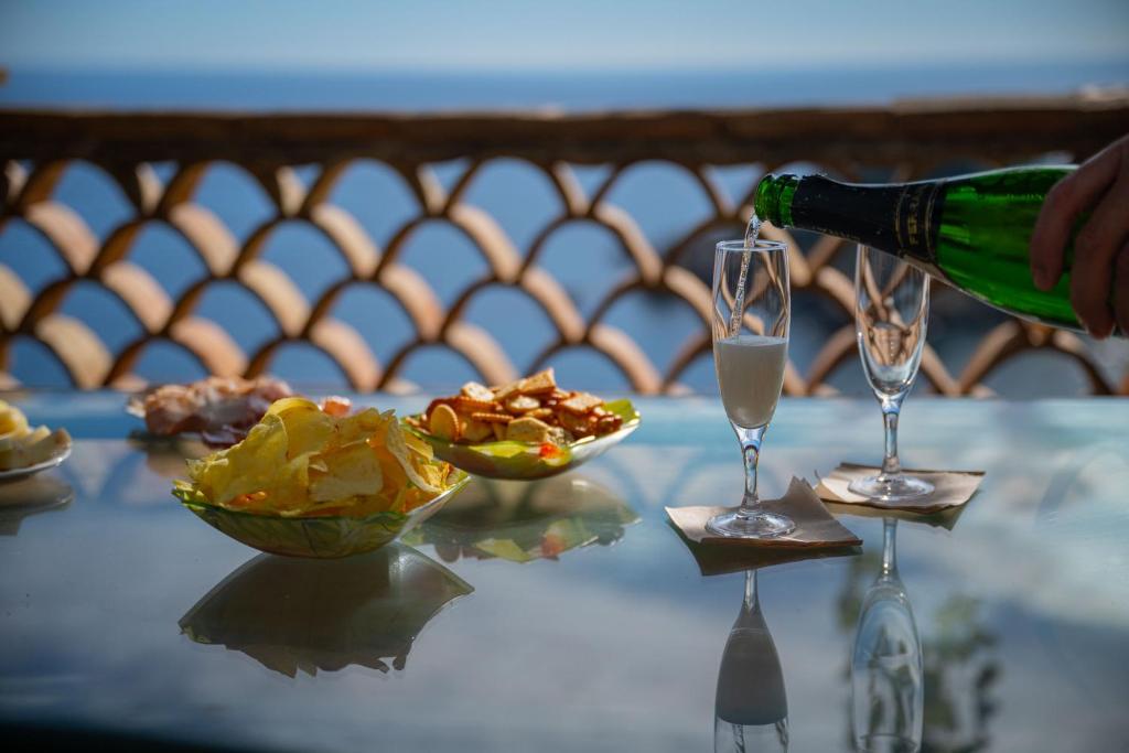 a person is pouring champagne into two glasses on a table at Mendolia Beach Hotel in Taormina