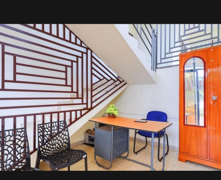 Pokój ze stołem, krzesłami i schodami w obiekcie BENCH HOTEL VAGAMON w mieście Vagamon