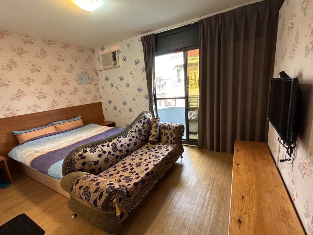 1 dormitorio con cama, sofá y TV en 若華軒民宿Ruohuaxuan, en Fang-liao