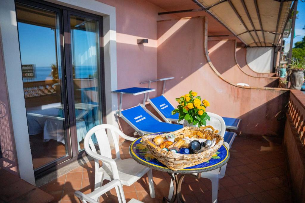 a basket of fruit on a table on a balcony at Mendolia Beach Hotel in Taormina