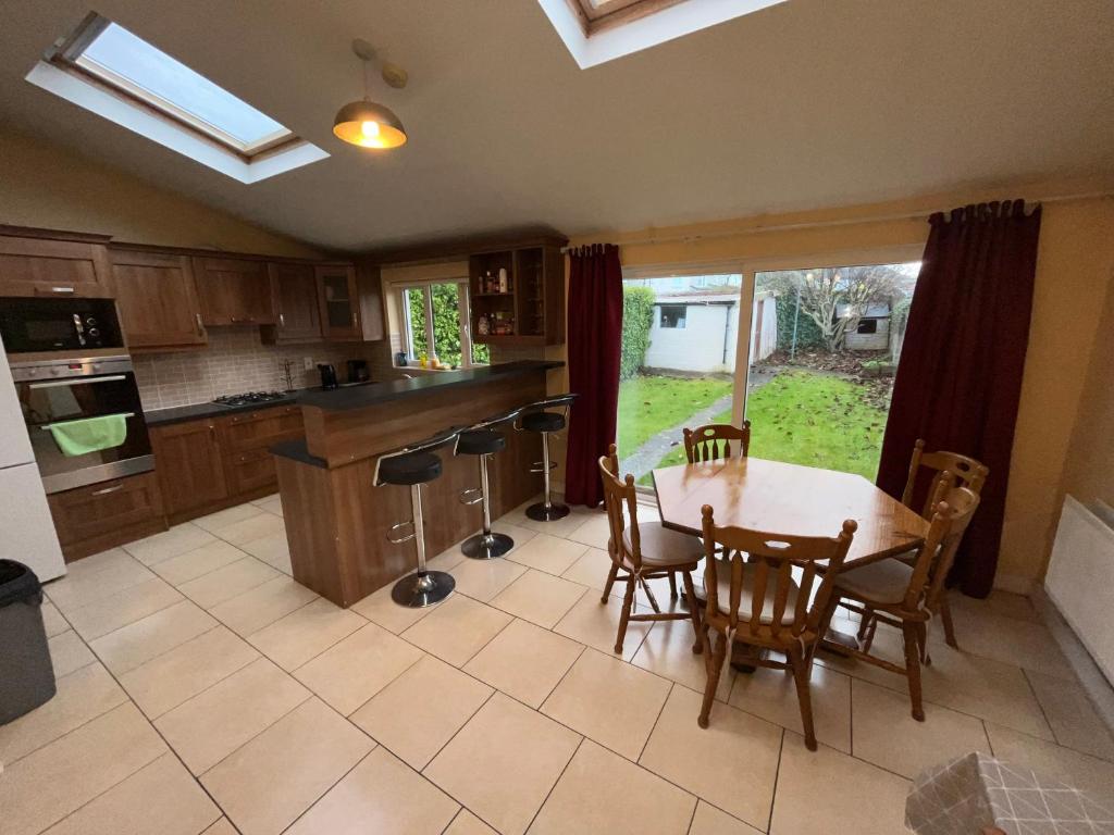 a kitchen with a wooden table and chairs and a table at The Walkinstown Property in Dublin
