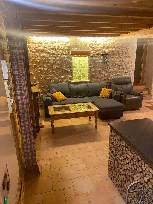 ein Wohnzimmer mit einem Sofa und einem Couchtisch in der Unterkunft Appartement chaleureux (chalets) in Rencurel