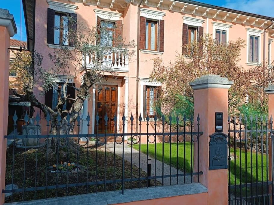 una casa rosa con una recinzione nera e un cancello di Casa Argia a Padova