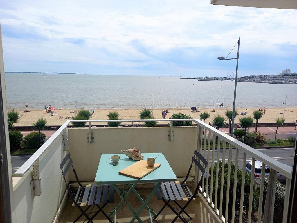 une table sur un balcon avec vue sur la plage dans l'établissement Royan - VUE MER pour cet APPARTEMENT face à la PLAGE - GRANDE CONCHE, à Royan